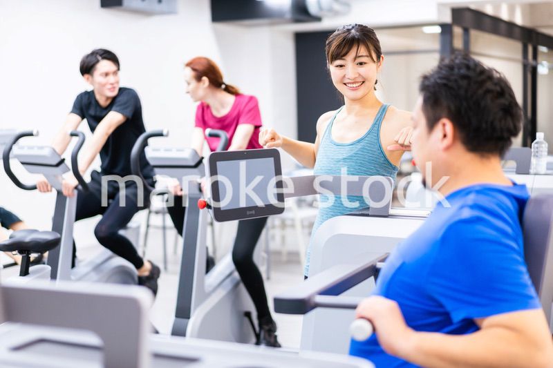 ジムでパーソナルトレーニングを受ける中年男性