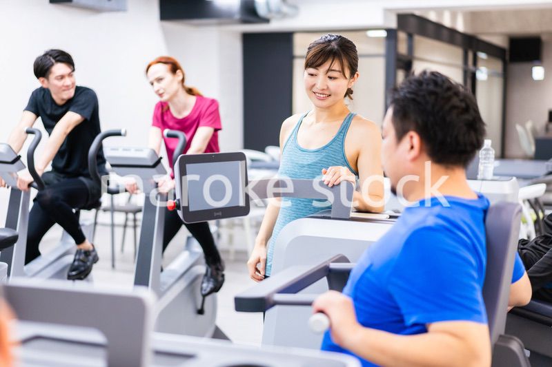 ジムでパーソナルトレーニングを受ける中年男性