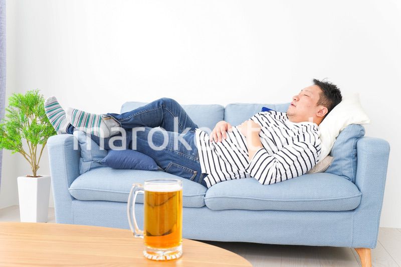 自宅でビールを飲む中年の男性