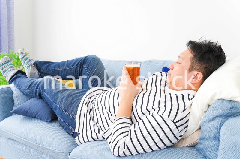 自宅でビールを飲む中年の男性