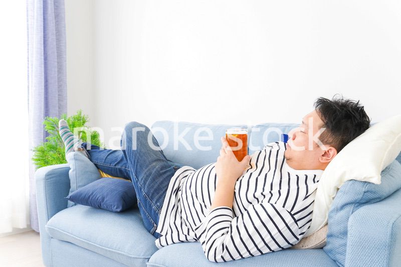 自宅でビールを飲む中年の男性