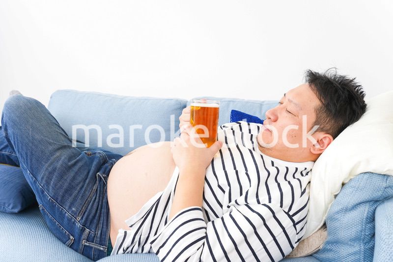 自宅でビールを飲む中年の男性