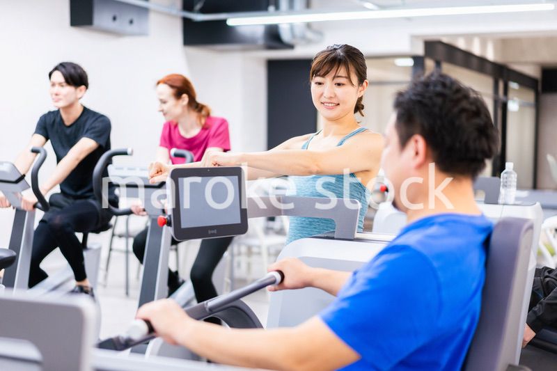 ジムでパーソナルトレーニングを受ける中年男性