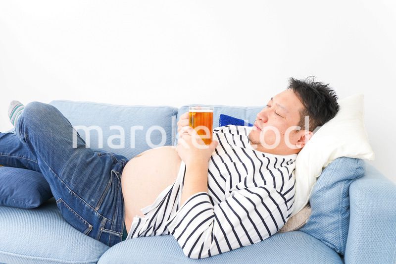 自宅でビールを飲む中年の男性