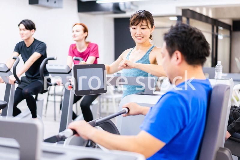 ジムでパーソナルトレーニングを受ける中年男性