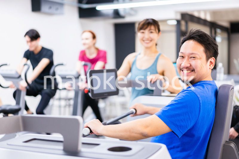 ジムでパーソナルトレーニングを受ける中年男性