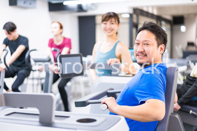 ジムでパーソナルトレーニングを受ける中年男性