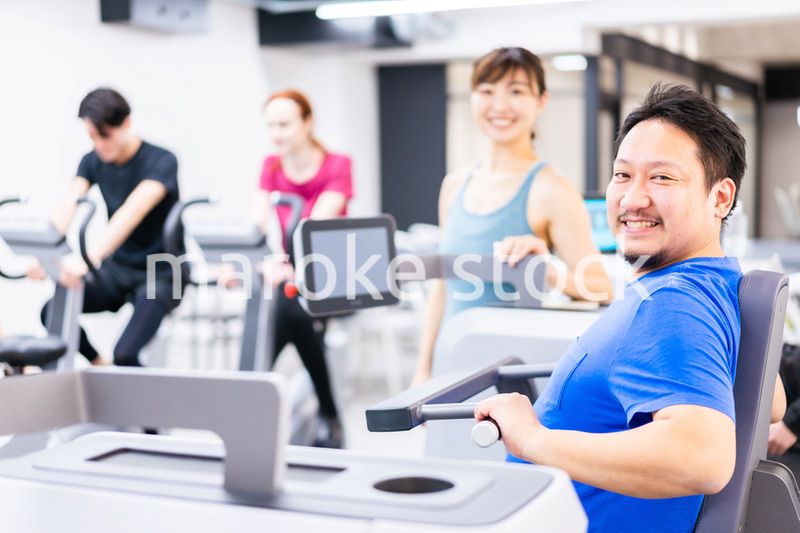 ジムでパーソナルトレーニングを受ける中年男性