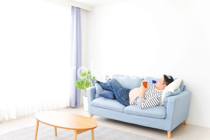 自宅でビールを飲む中年の男性