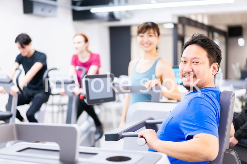 ジムでパーソナルトレーニングを受ける中年男性