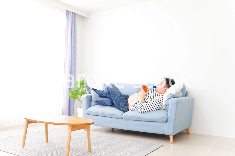 自宅でビールを飲む中年の男性