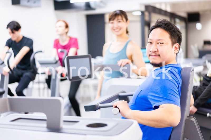 ジムでパーソナルトレーニングを受ける中年男性