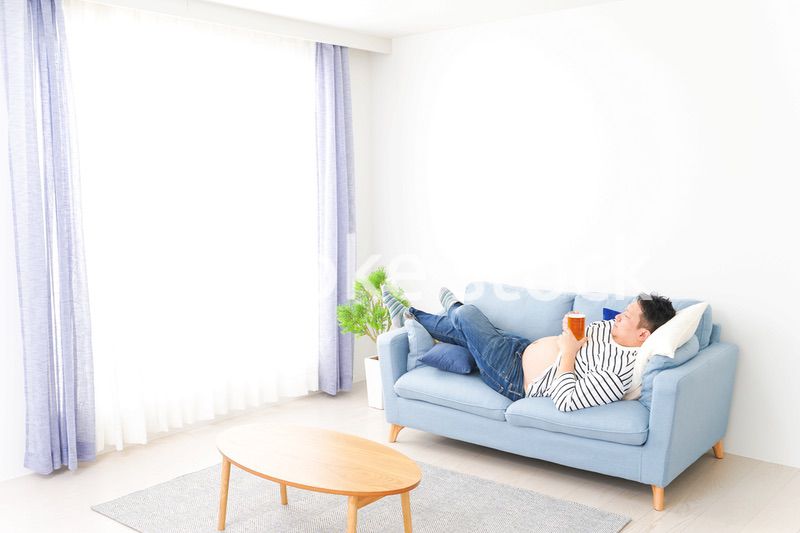自宅でビールを飲む中年の男性