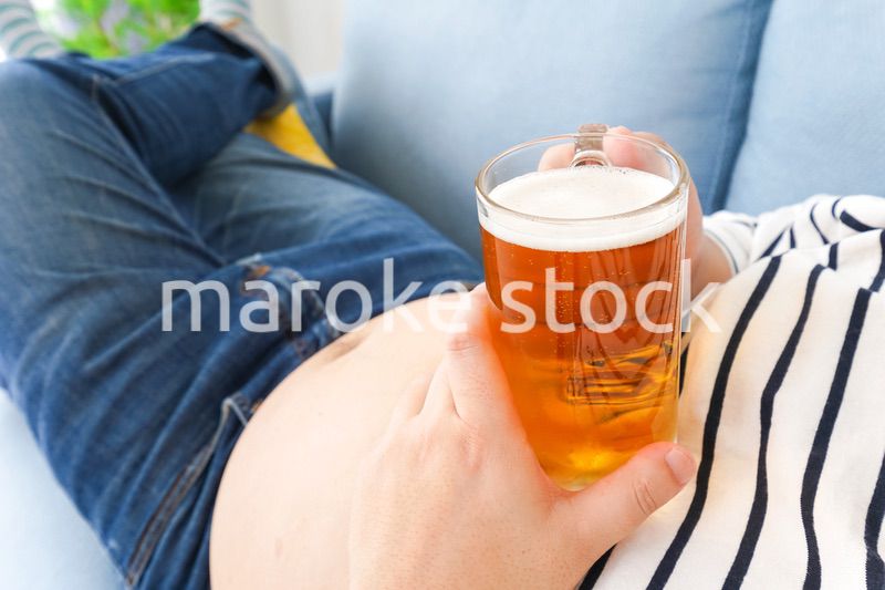 自宅でビールを飲む中年の男性