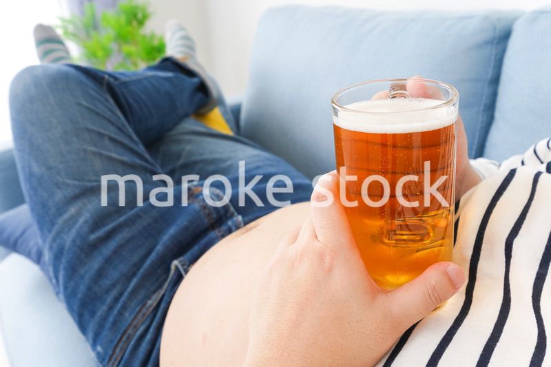 自宅でビールを飲む中年の男性