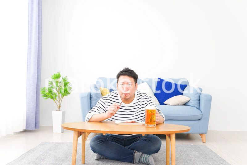 自宅でビールを飲む中年の男性