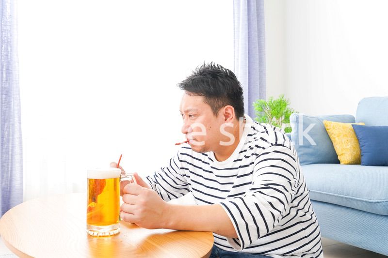 自宅でビールを飲む中年の男性