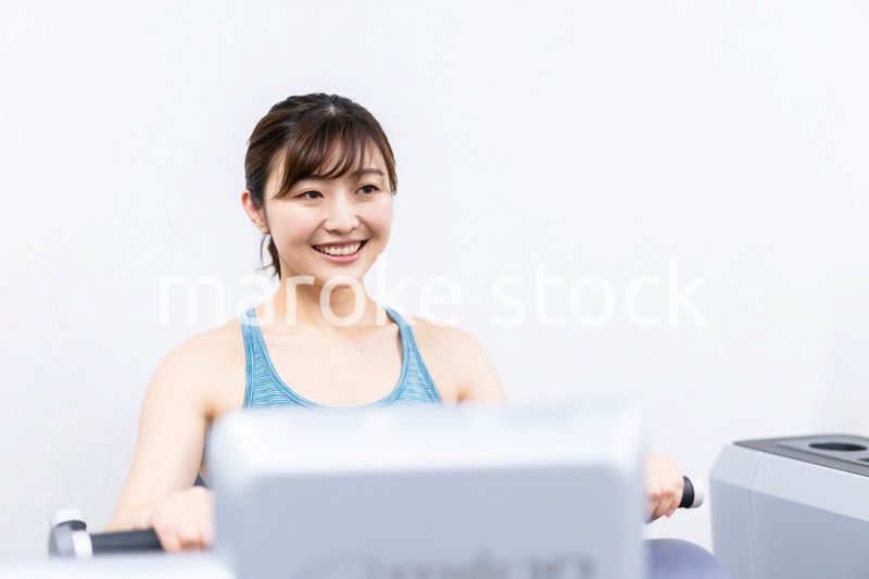 ジムで筋トレをする若い女性