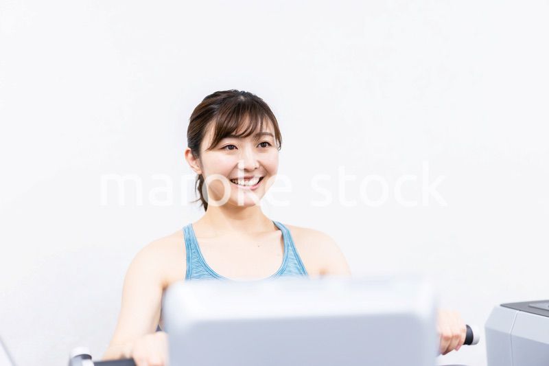 ジムで筋トレをする若い女性