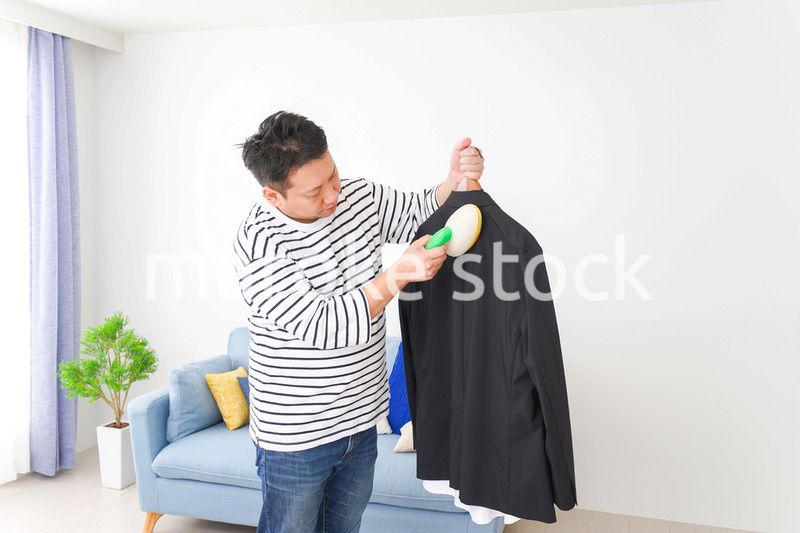 スーツの手入れをする中年の男性