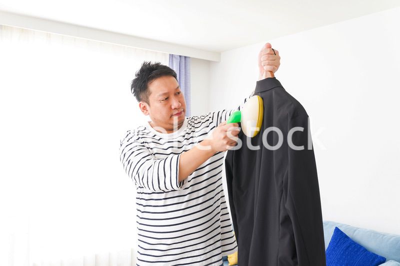 スーツの手入れをする中年の男性