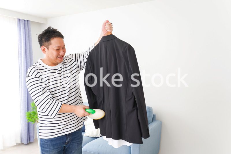 スーツの手入れをする中年の男性