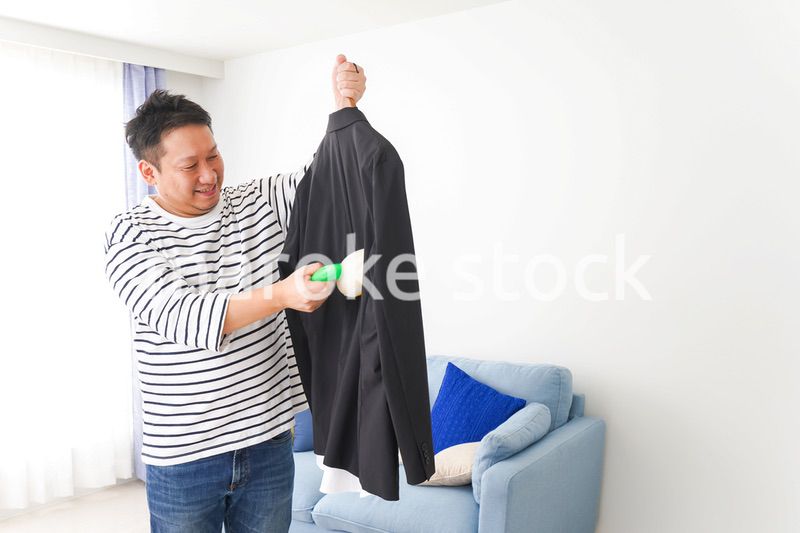 スーツの手入れをする中年の男性