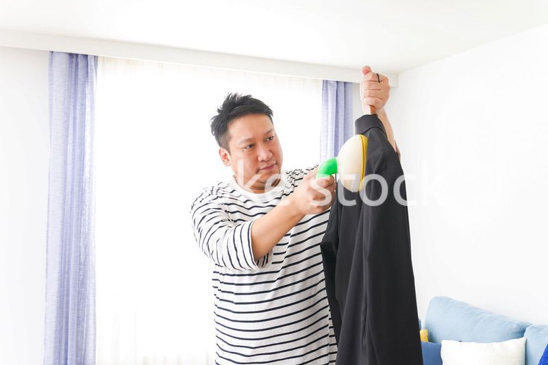 スーツの手入れをする中年の男性