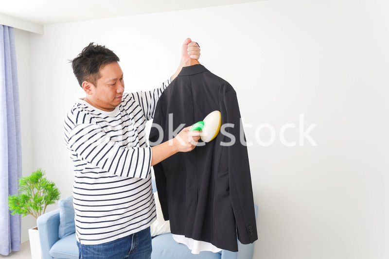 スーツの手入れをする中年の男性