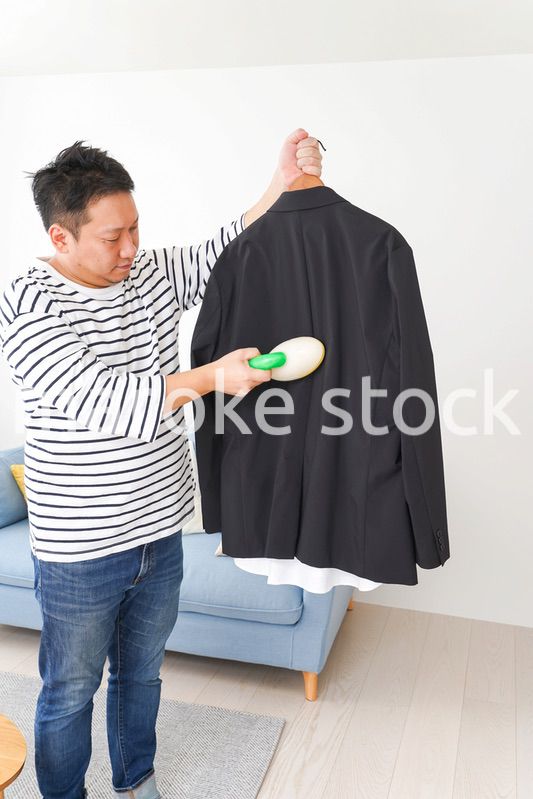 スーツの手入れをする中年の男性