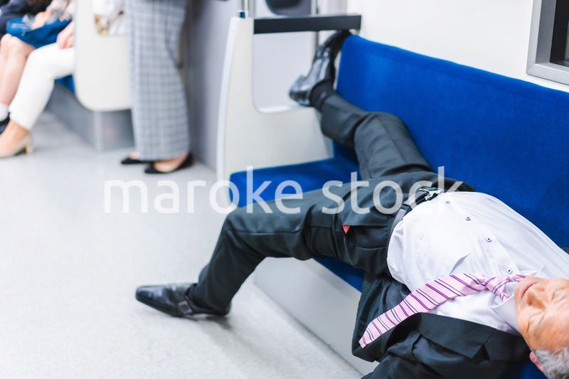 電車内で寝転ぶ中年男性