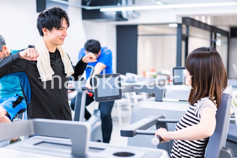 ジムでトレーナーの指導を受ける若い女性