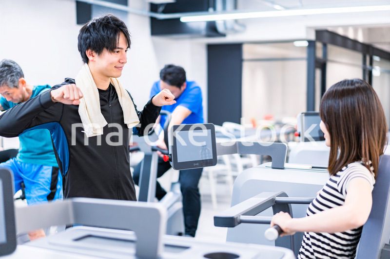 ジムでトレーナーの指導を受ける若い女性