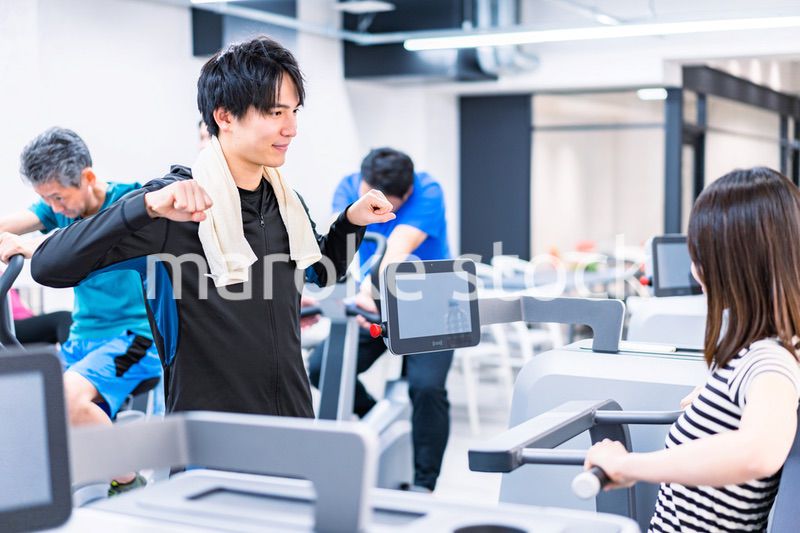 ジムでトレーナーの指導を受ける若い女性