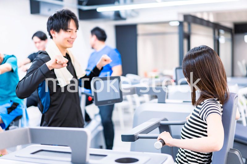 ジムでトレーナーの指導を受ける若い女性