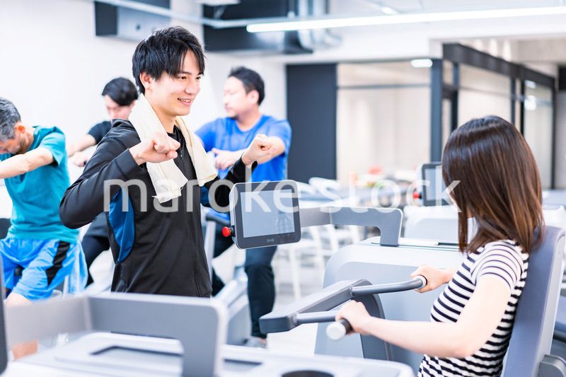 ジムでトレーナーの指導を受ける若い女性