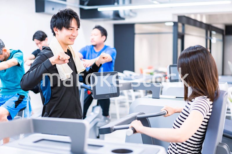 ジムでトレーナーの指導を受ける若い女性