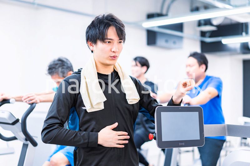 ジムでトレーナーの指導を受ける若い女性