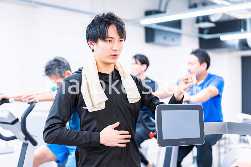 ジムでトレーナーの指導を受ける若い女性