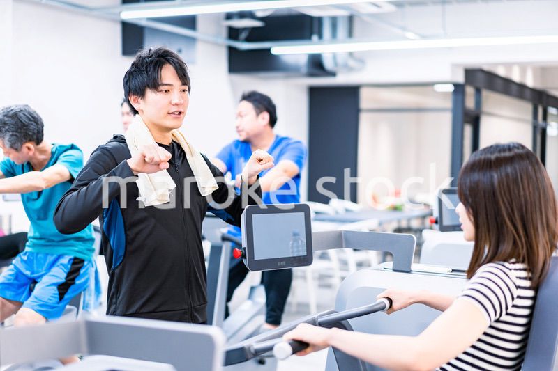 ジムでトレーナーの指導を受ける若い女性