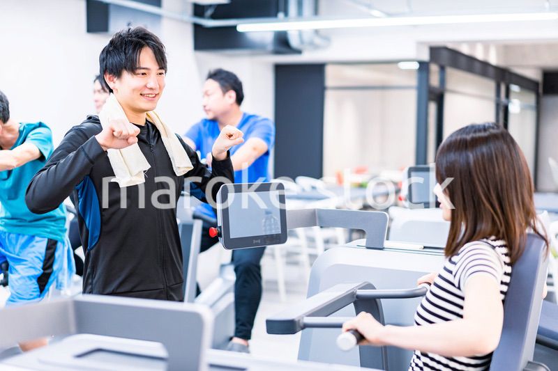 ジムでトレーナーの指導を受ける若い女性