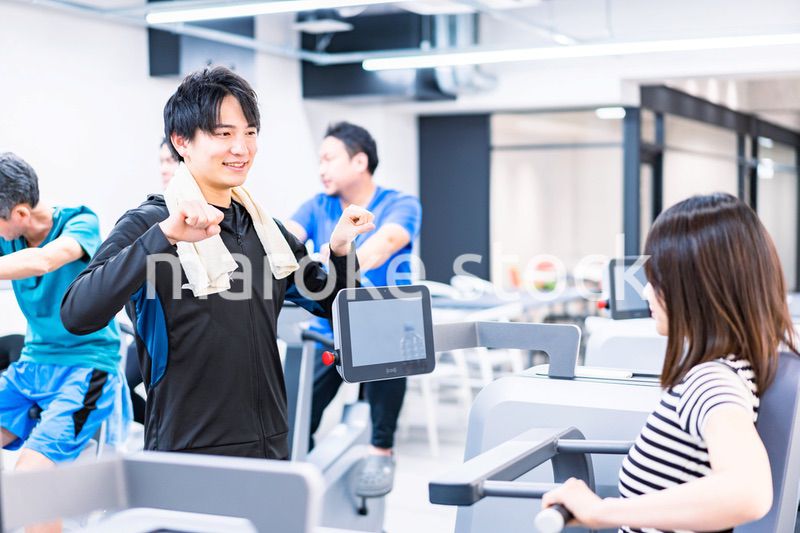 ジムでトレーナーの指導を受ける若い女性