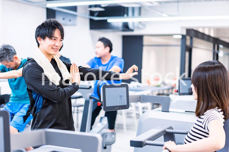 ジムでトレーナーの指導を受ける若い女性