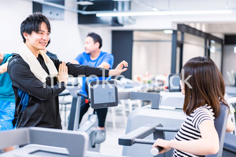 ジムでトレーナーの指導を受ける若い女性