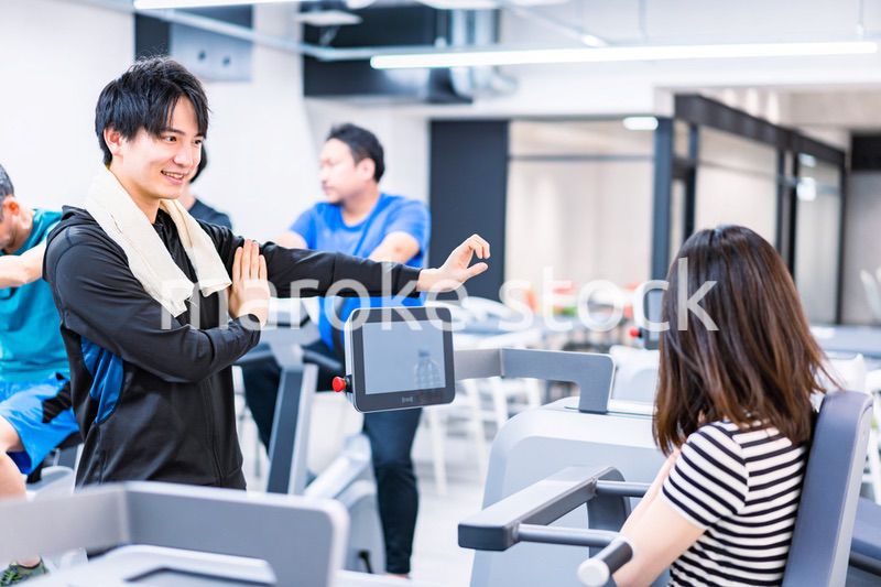 ジムでトレーナーの指導を受ける若い女性