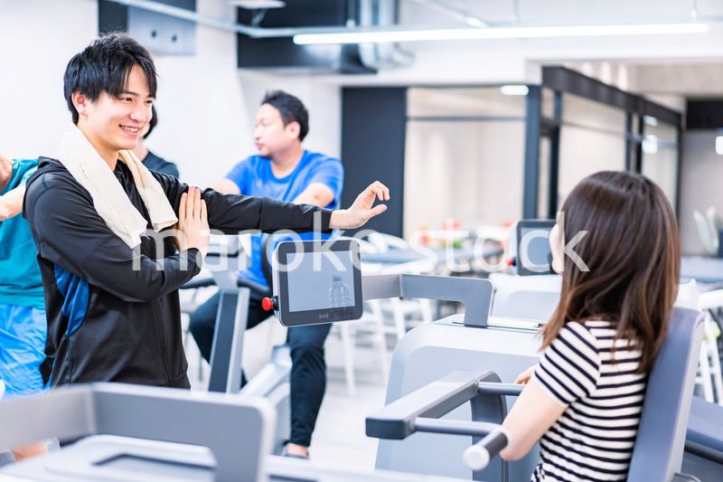 ジムでトレーナーの指導を受ける若い女性