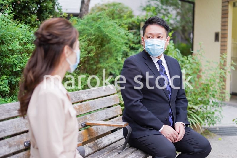 ソーシャルディスタンスを確保して会話をするビジネスパーソン