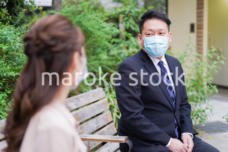 ソーシャルディスタンスを確保して会話をするビジネスパーソン