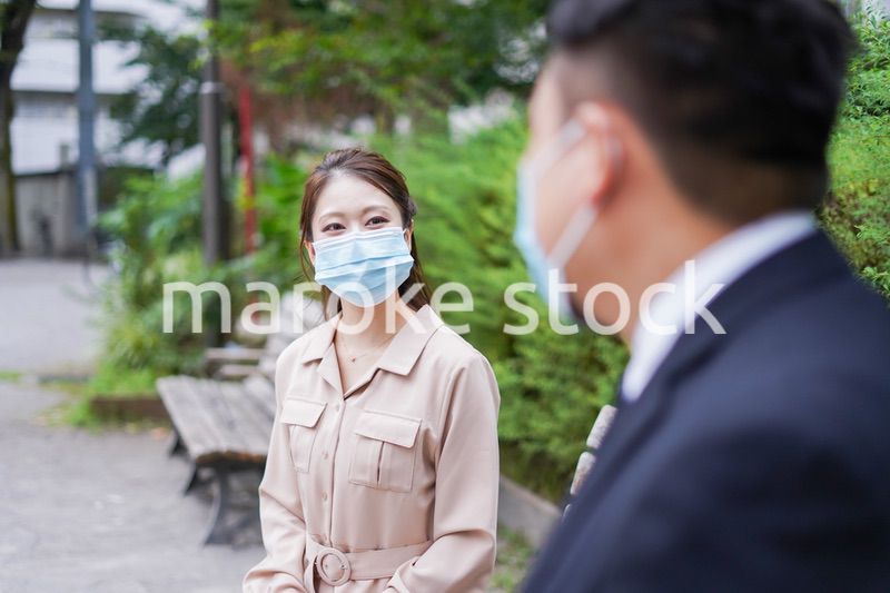 ソーシャルディスタンスを確保して会話をするビジネスパーソン