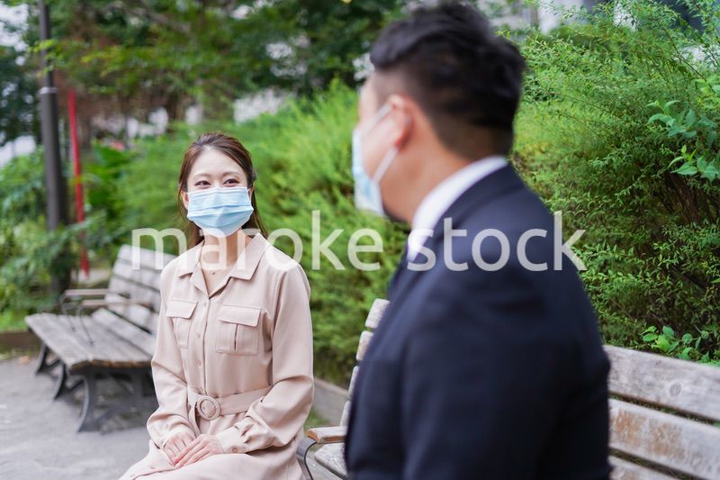 ソーシャルディスタンスを確保して会話をするビジネスパーソン